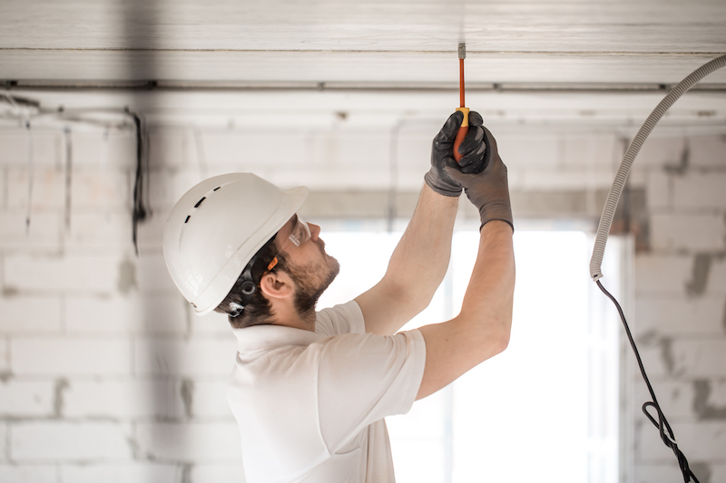 electrician-installer-with-tool-his-hands-working-with-cable-construction-site-1